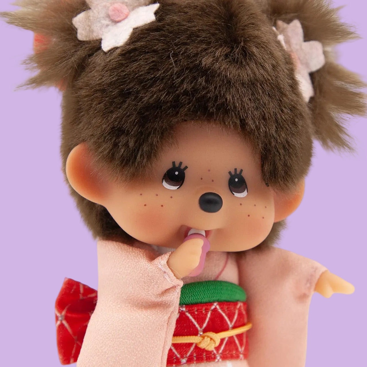 A Monchhichi keychain wearing a kimono. She has flowers in her hair.