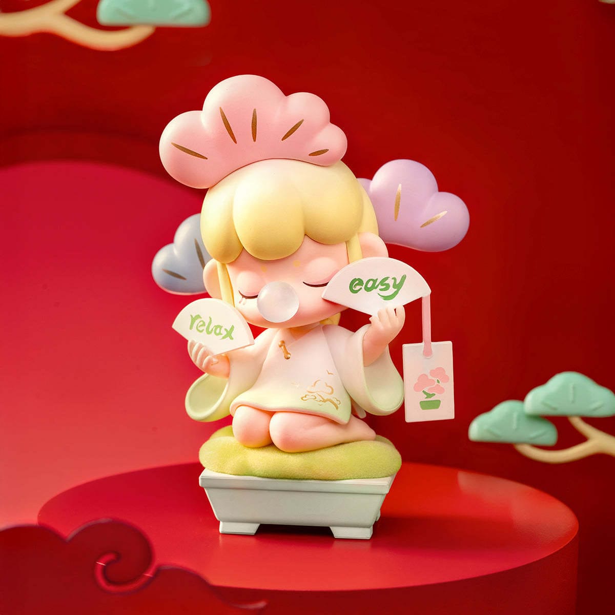 A figure of a little girl sitting on a stool. She is holding fans that say "easy", and "relax". She is blowing a gum bubble.