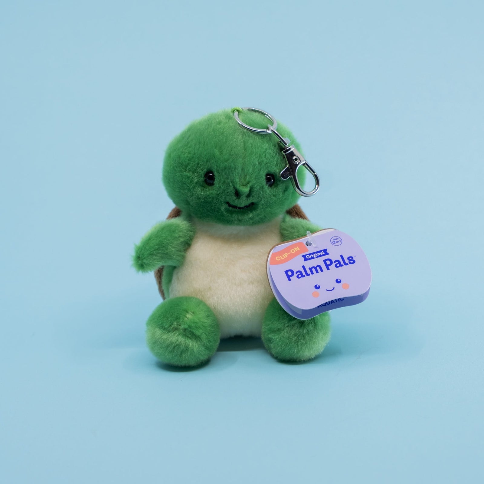 A cute turtle plush key chain. It has a tag with text reading "Palm Pals".