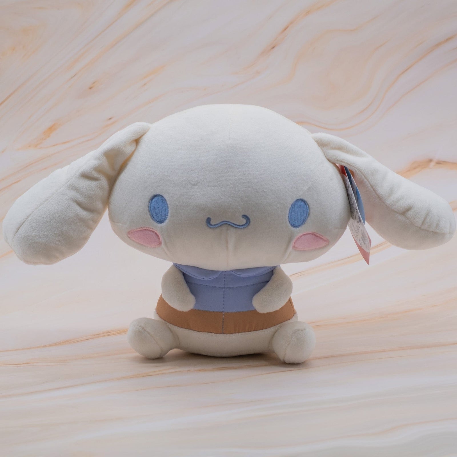 A plush of a rabbit with a large head. The rabbit is also wearing a blue shirt.