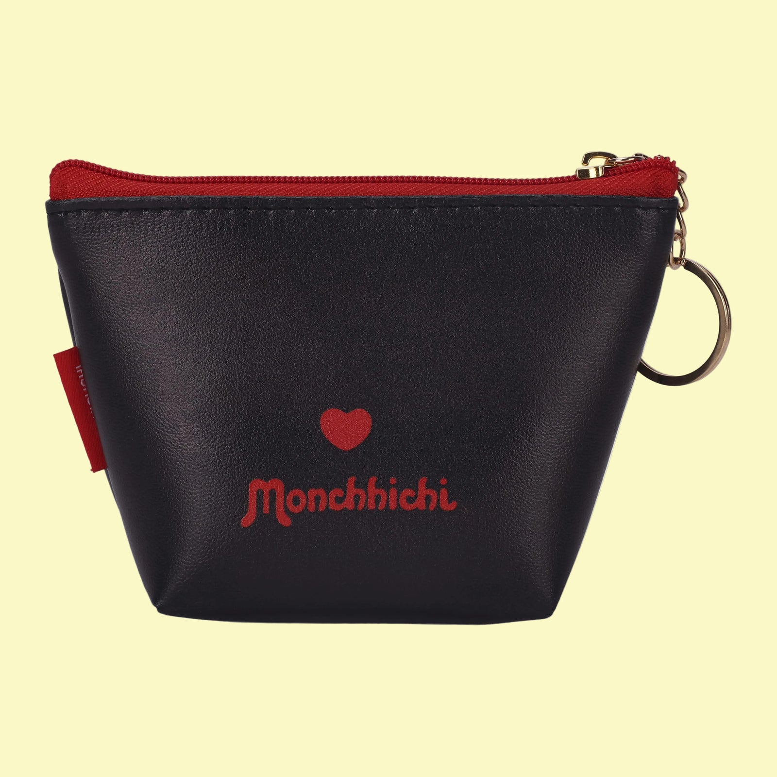 The back of a black coin purse. There is a red heart, and red text reading "Monchhichi".
