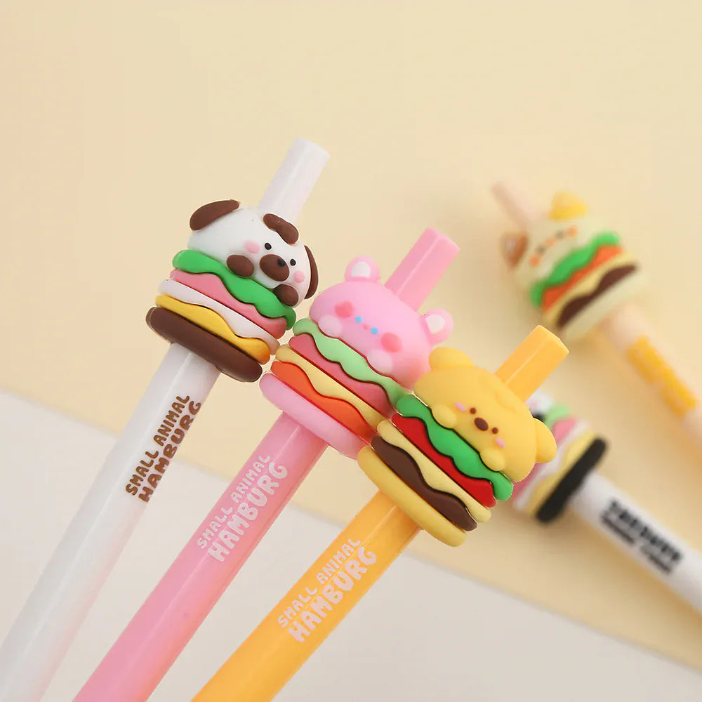 Three pens with toppers on them. The toppers are little cheeseburgers with animal faces.