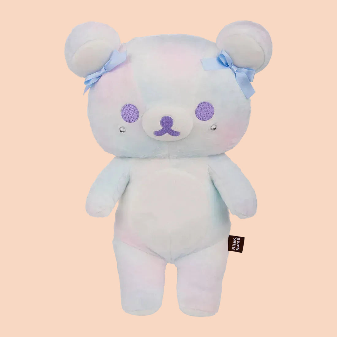 A white bear plush with blue bows on its ears.