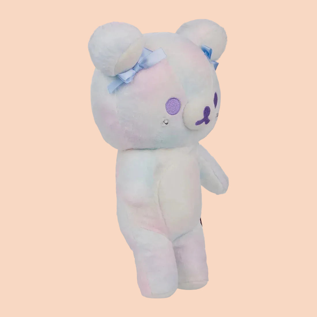 A white bear plush with blue bows on its ears.