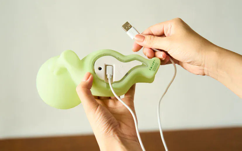 Underside view of a figurine showing an attached USB A charger.
