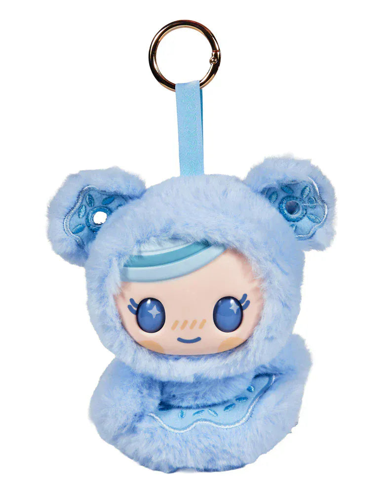 A cute plushie of a child in a furry, blue onesie with donuts for ears. It has large sparkly eyes.