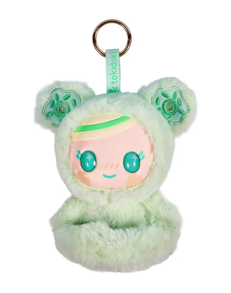 A cute plushie of a child in a furry, green onesie with donuts for ears. It has large sparkly eyes.