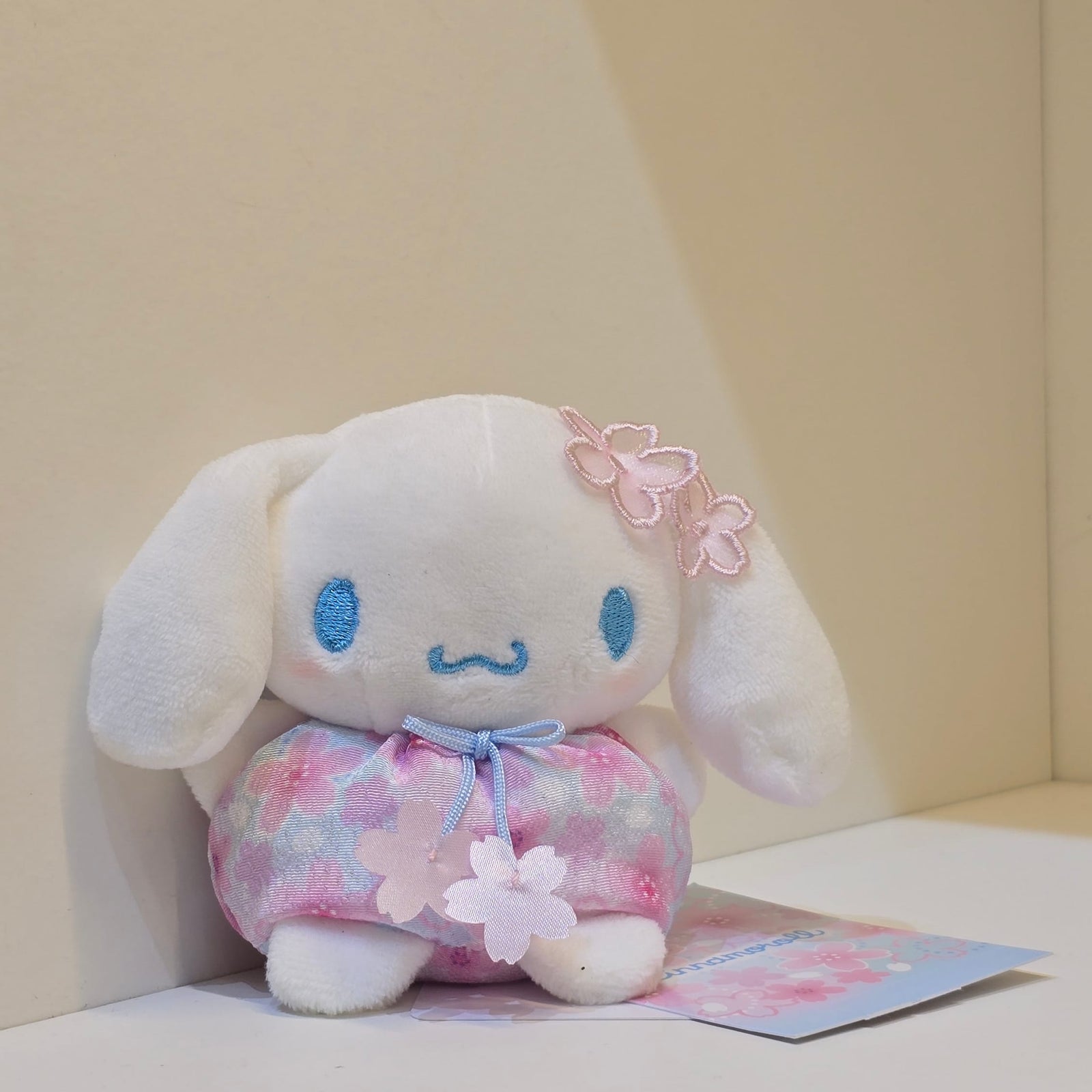 A cute Cinamoroll plush in a blue flower outfit.