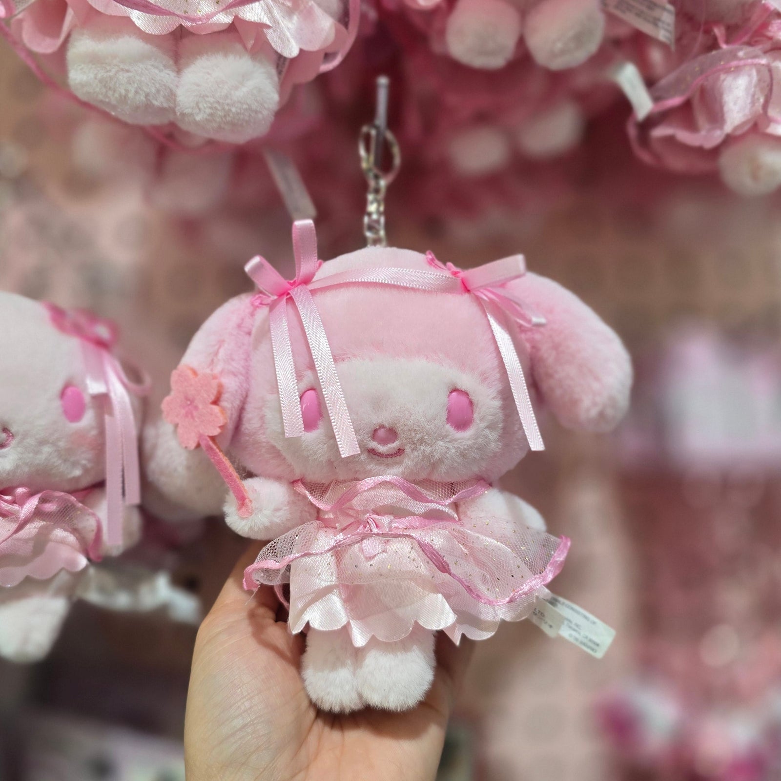 A pink My Melody plush key chain. She is holding a ink flower wand.