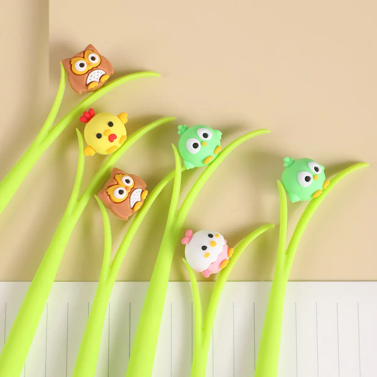 Several pens designed to look like grass blades with cute little bird toppers on them.
