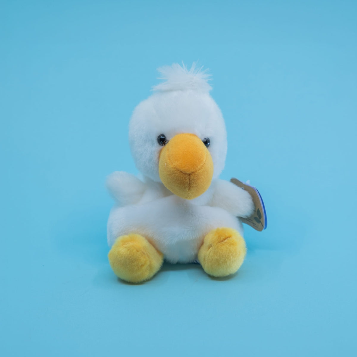 A cute plush of a blue bird with a big yellow beak.
