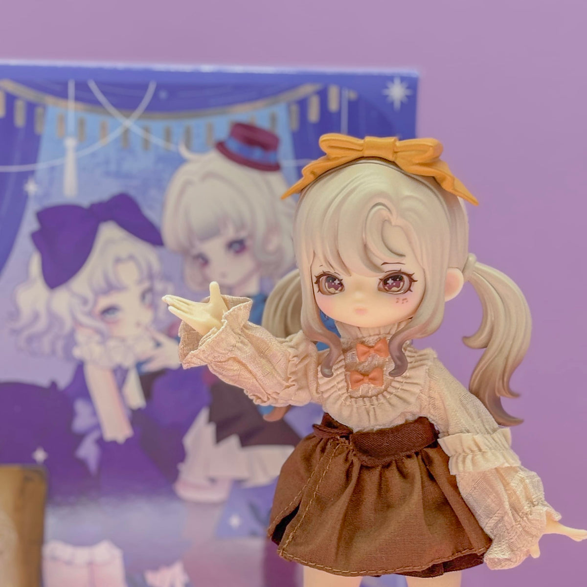 A figurine of an anime girl with grey hair. She has starry eyes and is wearing a yellow bow in her hair.