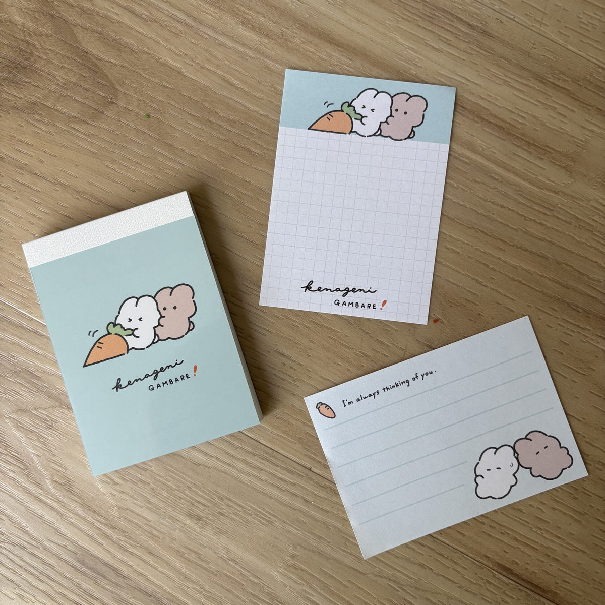 A notepad with illustrations of two cute rabbit characters attempt to pull a giant carrot.