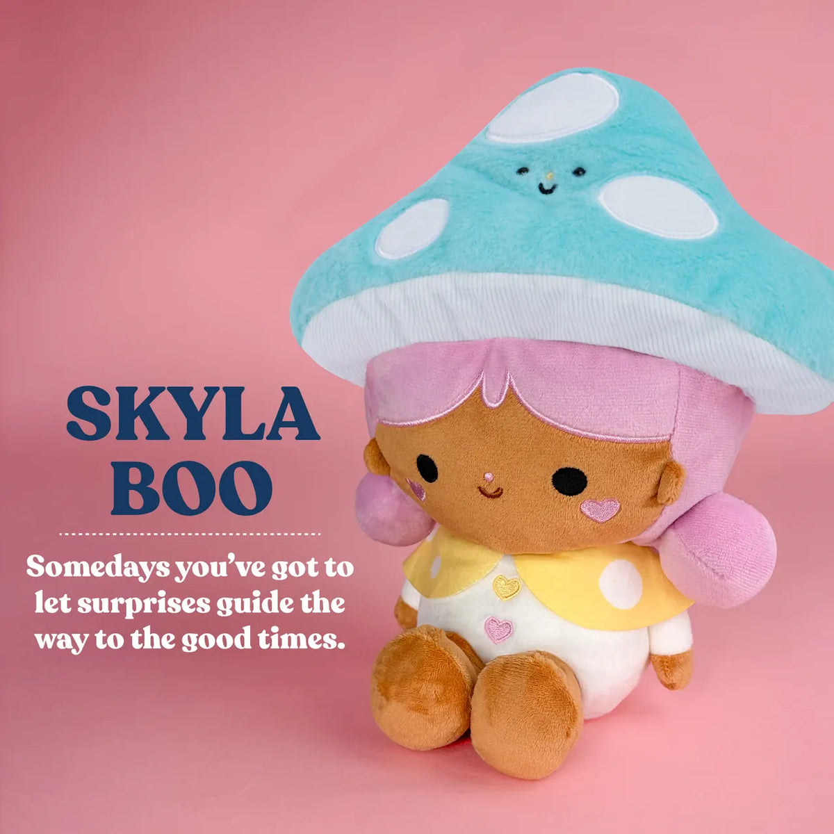 A cute plush of a girl wearing a bright blue mushroom hat. There is text reading "Skyla Boo. Some days you've got to let surprises guide the way to the good times".