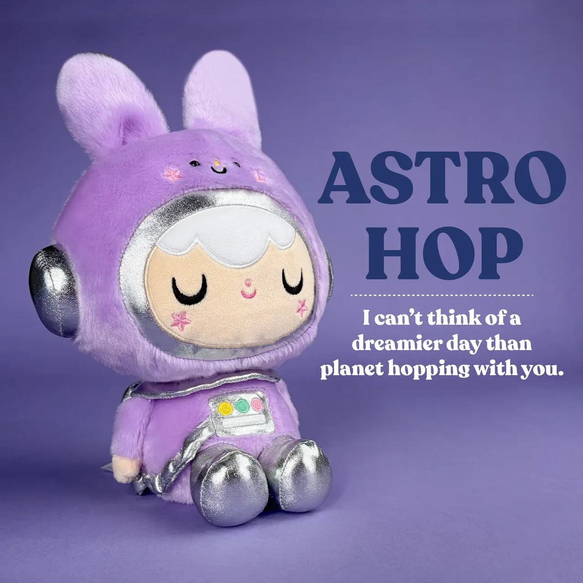 A cute plush of a girl in a purple, space themed, bunny outfit. There is text reading "Astro Hop. I can't think of a dreamier day than planet hopping with you".