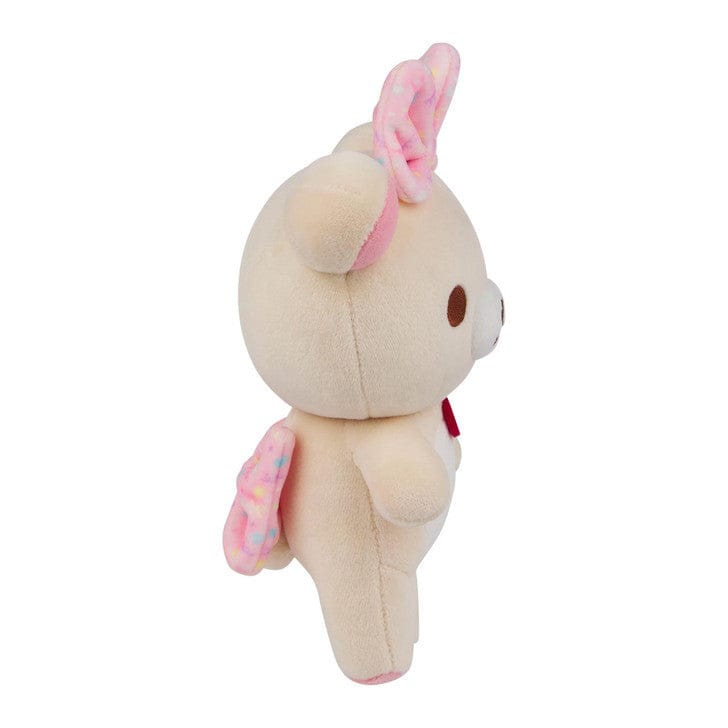 Sideways view of a bear plushie with a pink bow on its head and back.