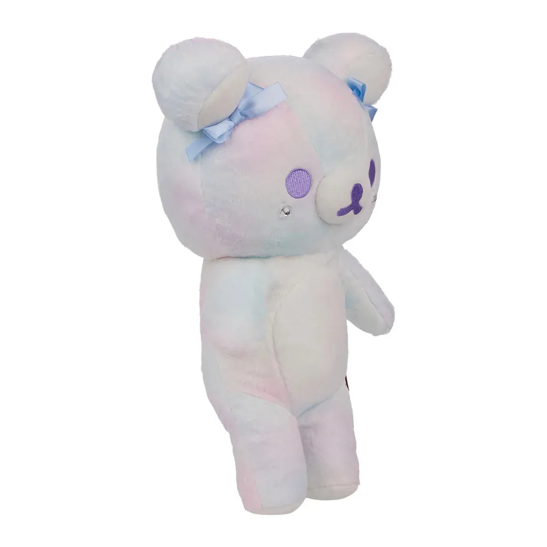 A white bear plush with blue bows on its ears.
