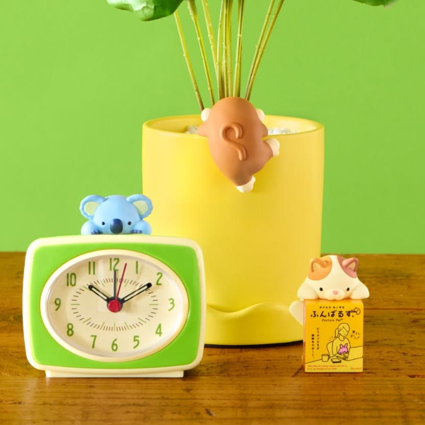 Various cute animal hippers attached to a potted plant, and a clock.