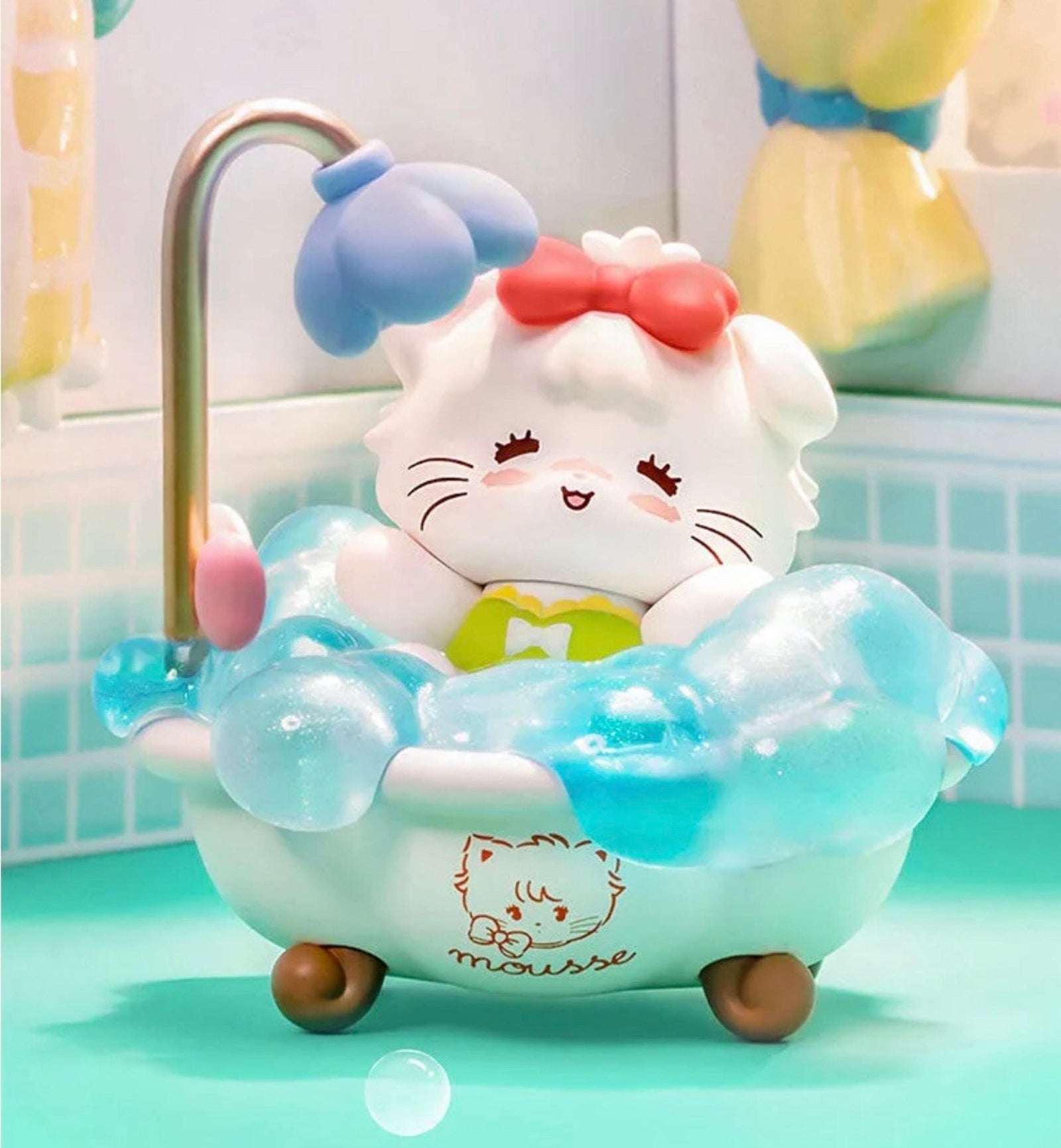 A figure of a cute little cat in the bath. The cat is happy and is wearing a little red bow.