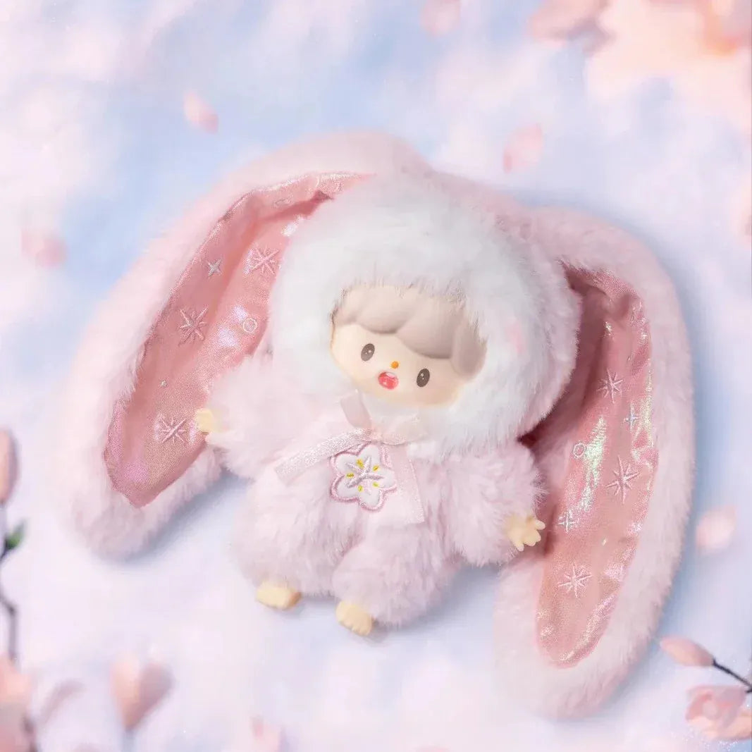 A figurine of a child in a pink fluffy rabbit costume. The costume's ears are as long as the child's body.