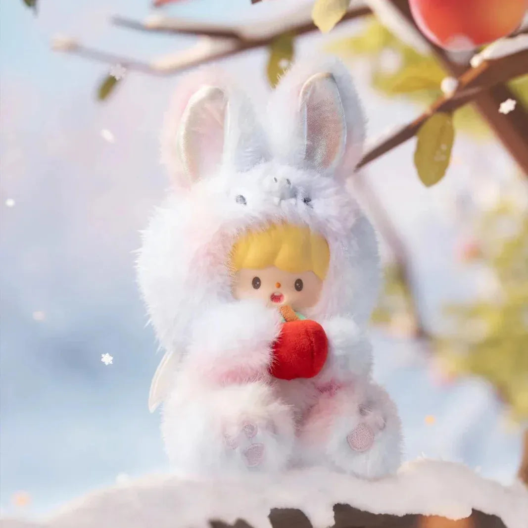 A figurine of a child in a fluffy rabbit costume holding a small apple plush.